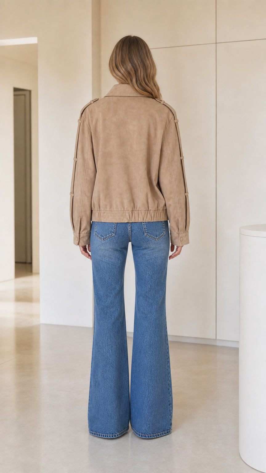 Back view of model wearing camel cropped faux suede jacket showing hem and shoulders