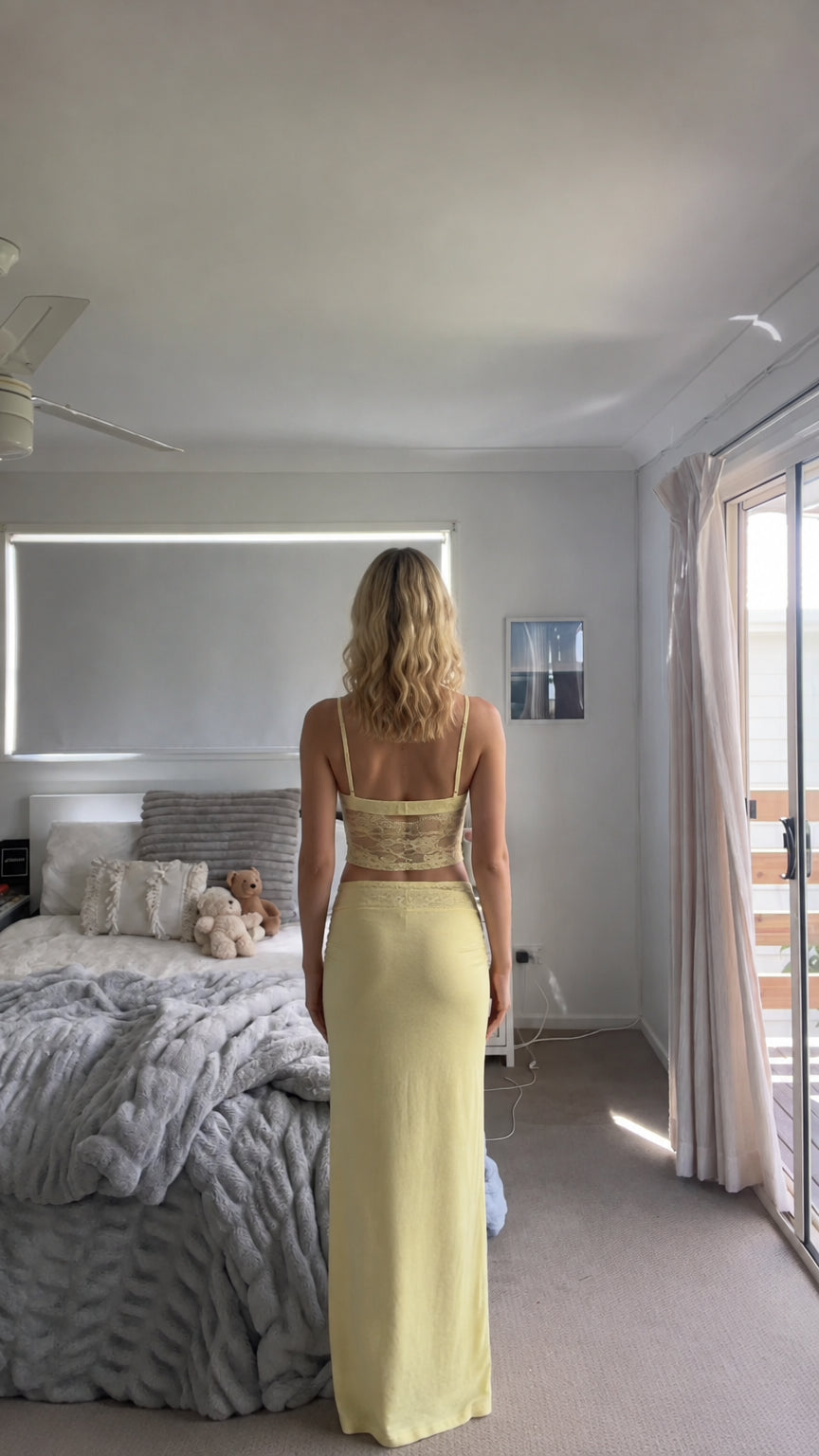 Back view of model in butter yellow lace two-piece maxi skirt set
