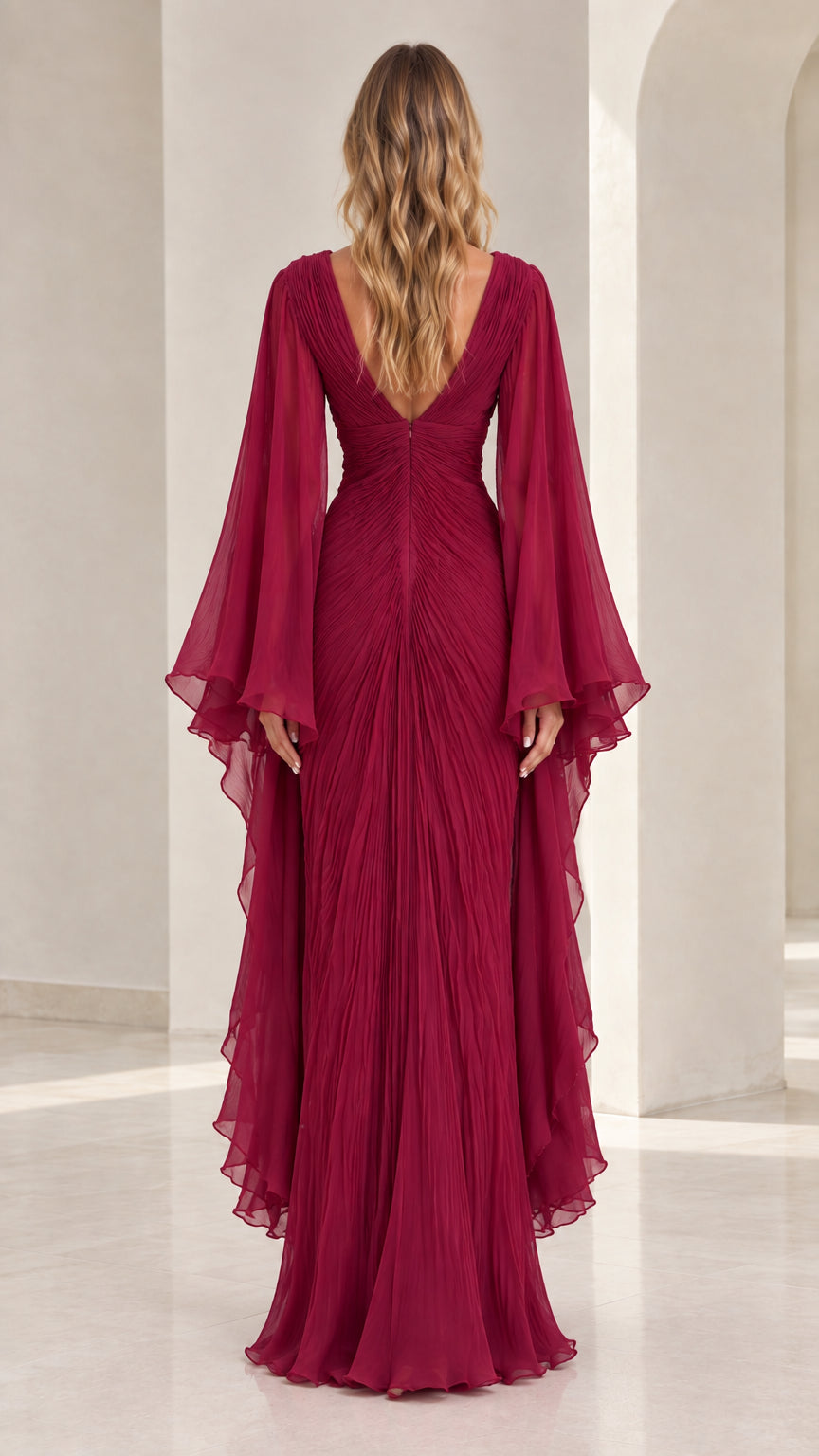 Back view of model wearing burgundy pleated evening dress with deep V-back design