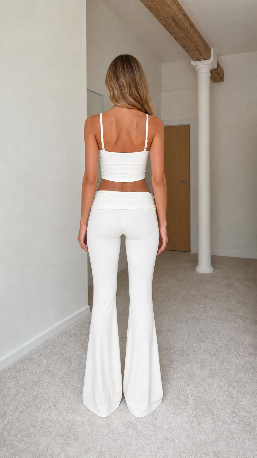Back view of model wearing cream white cropped camisole and flare pants set