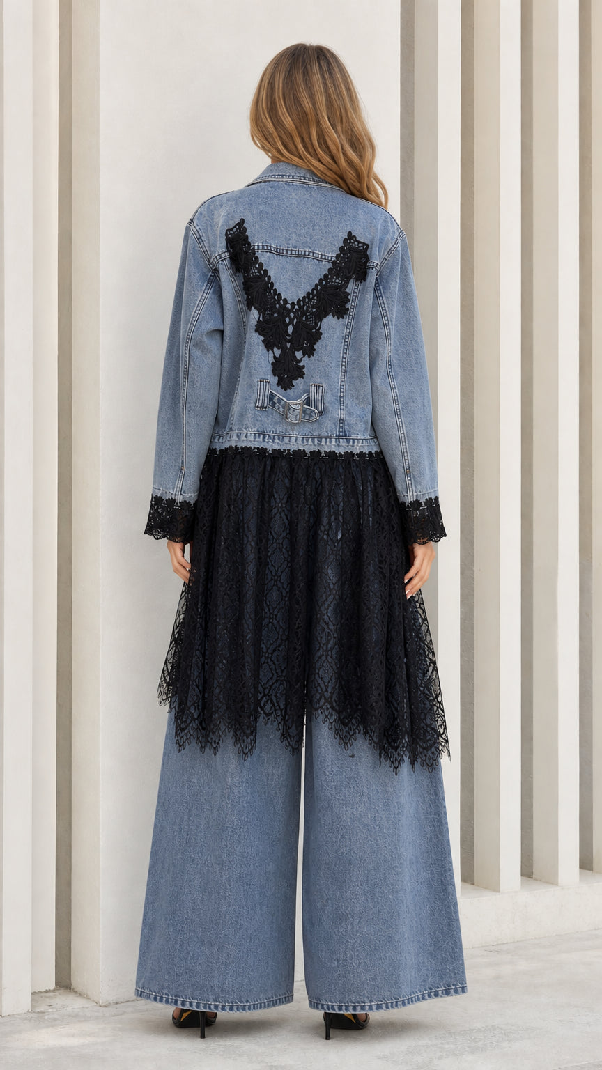 Back view of light blue denim jacket showing V-shaped black lace appliqué and sheer hem