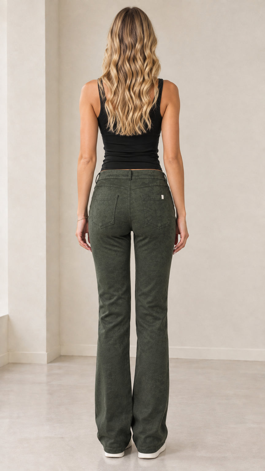 Back view of model showing the fit and back pockets of olive green bootcut trousers