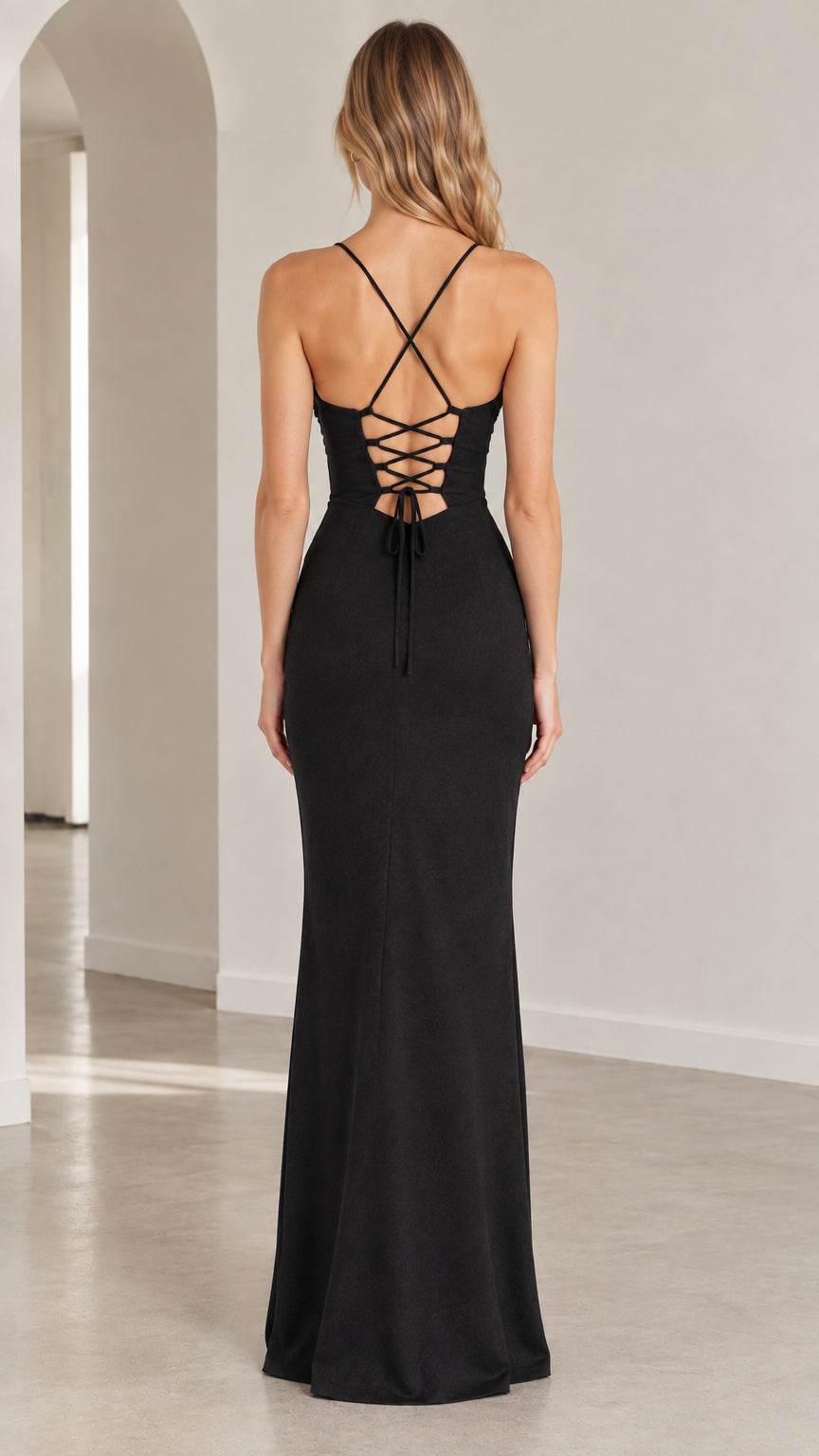 Back view of model showing the crisscross lace-up open back design on the black gown
