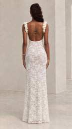 Back view of white lace maxi dress featuring deep scoop open back and ruffled straps