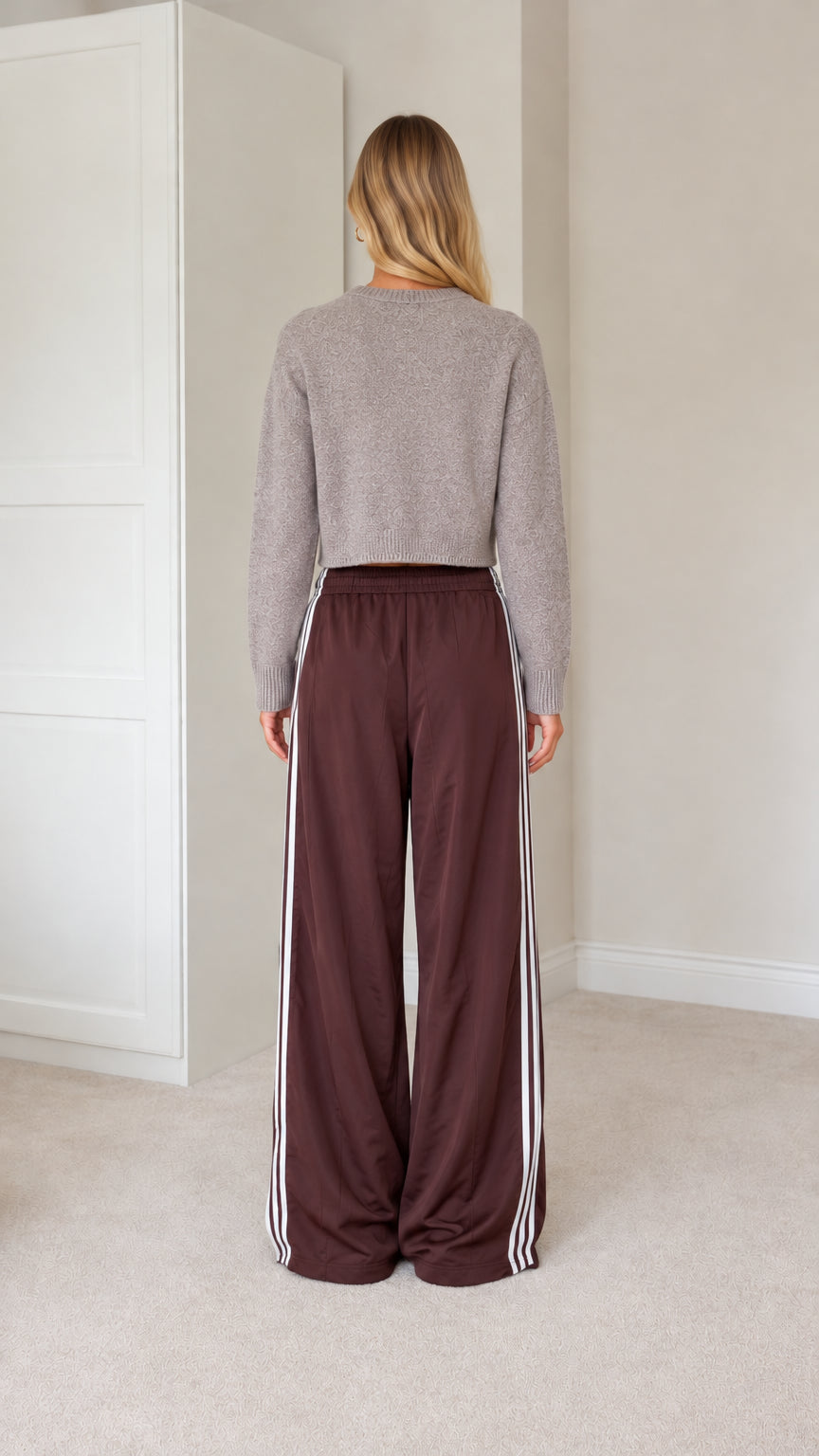 Rear view of model wearing grey knit cardigan and brown wide leg track pants