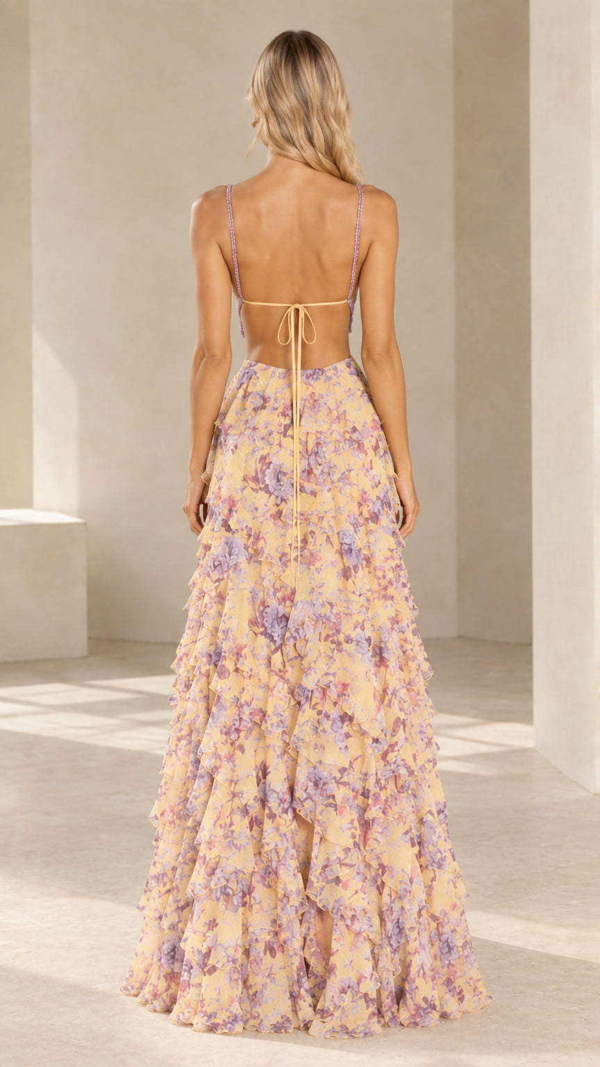 Rear view of yellow floral evening dress showing lace-up open back and tiered cascading skirt