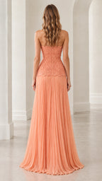 Back view of model wearing peach strapless lace and pleated maxi dress