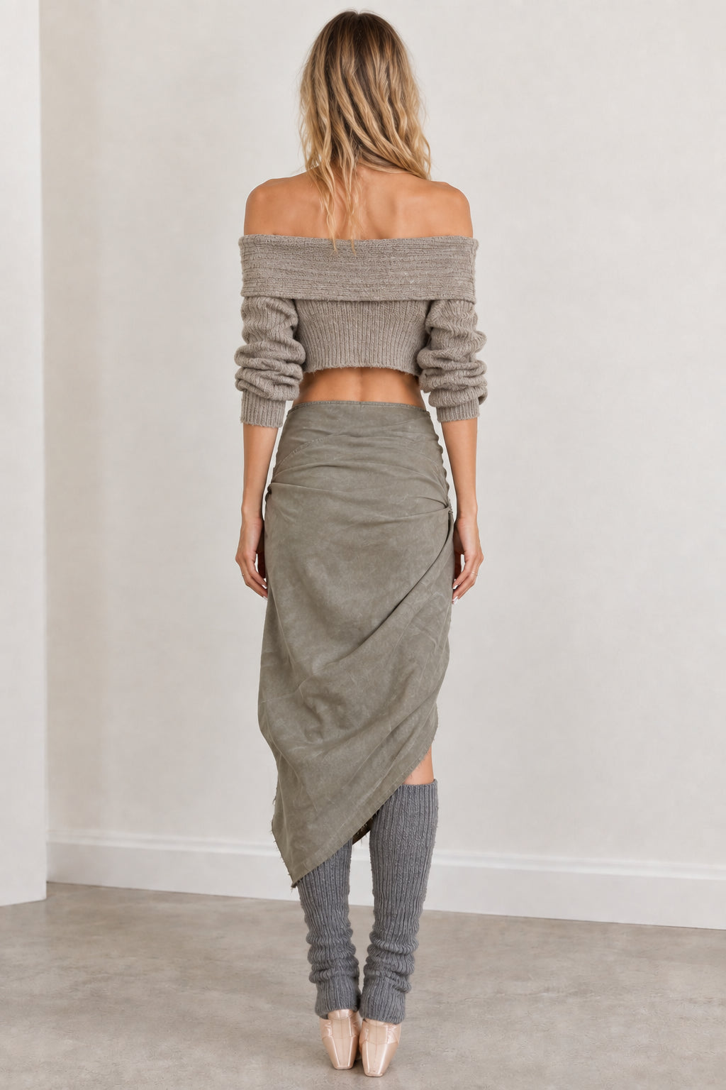 Back view of woman wearing sage green off-shoulder cropped sweater and draped skirt