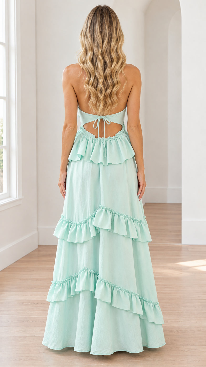 Back view of mint green maxi dress showing open cutout back and tie bow