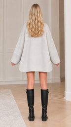 Back view of model in light grey cape coat showing relaxed A-line drape