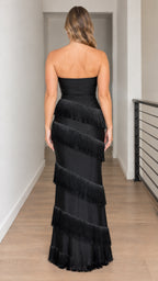 Back view of woman wearing strapless black tiered fringe evening gown with straight backline