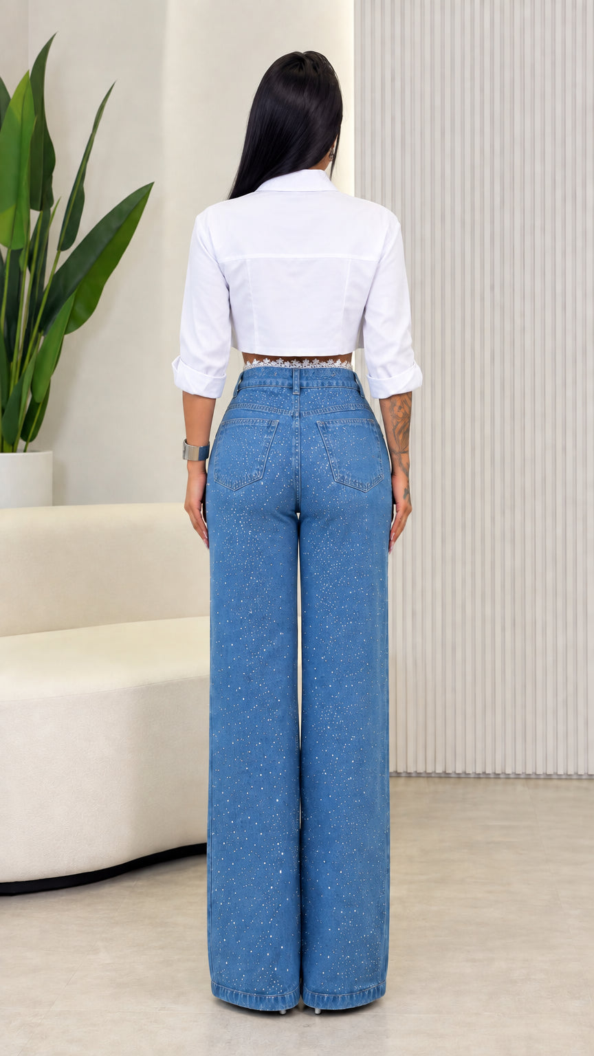 Back view of blue rhinestone embellished wide leg pants with white long sleeve cropped shirt