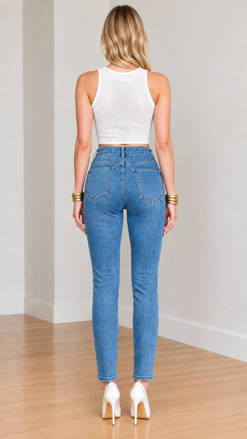 Back full-length view of model wearing high-waisted blue jeans showing classic back pocket fit