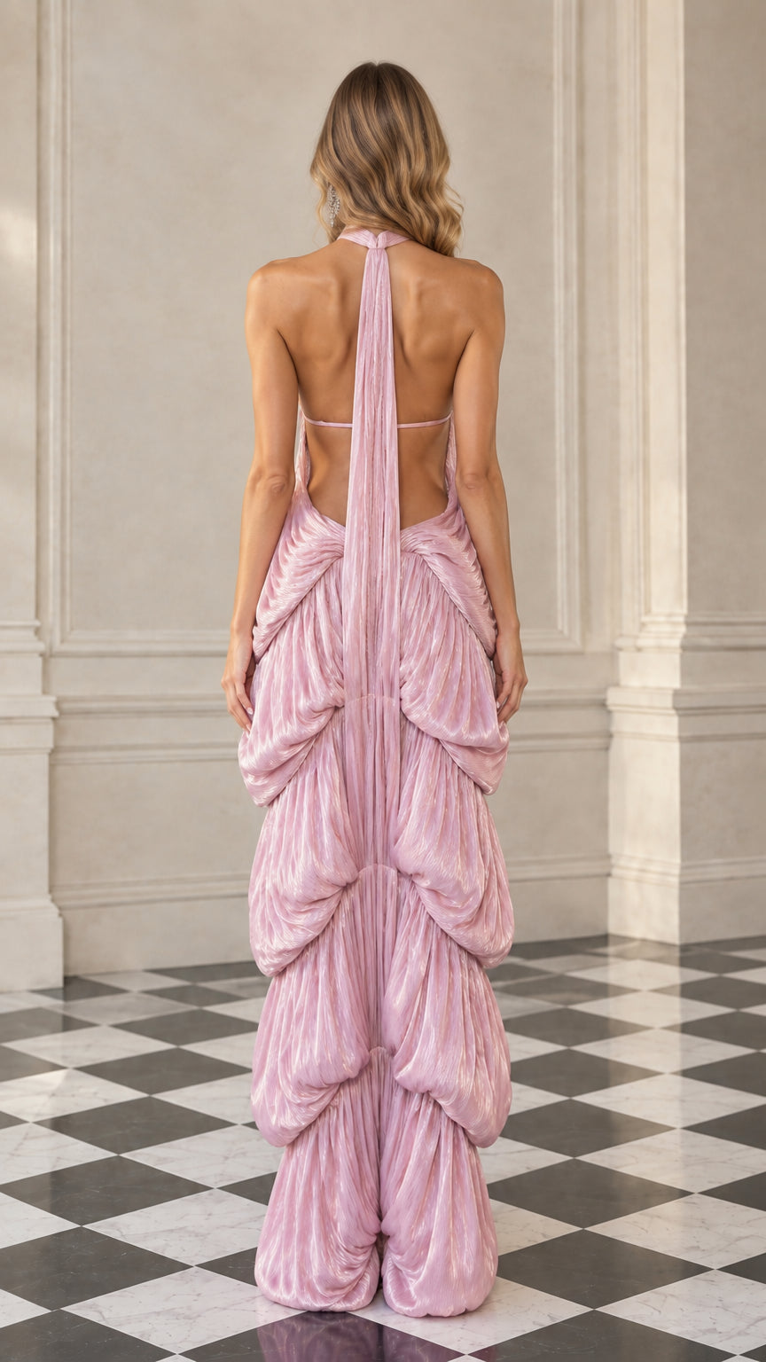 Back view of model showing open back silhouette and trailing halter ties in dusty pink