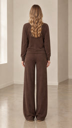 Back full-length view of woman wearing brown ribbed knit cardigan and wide-leg pants