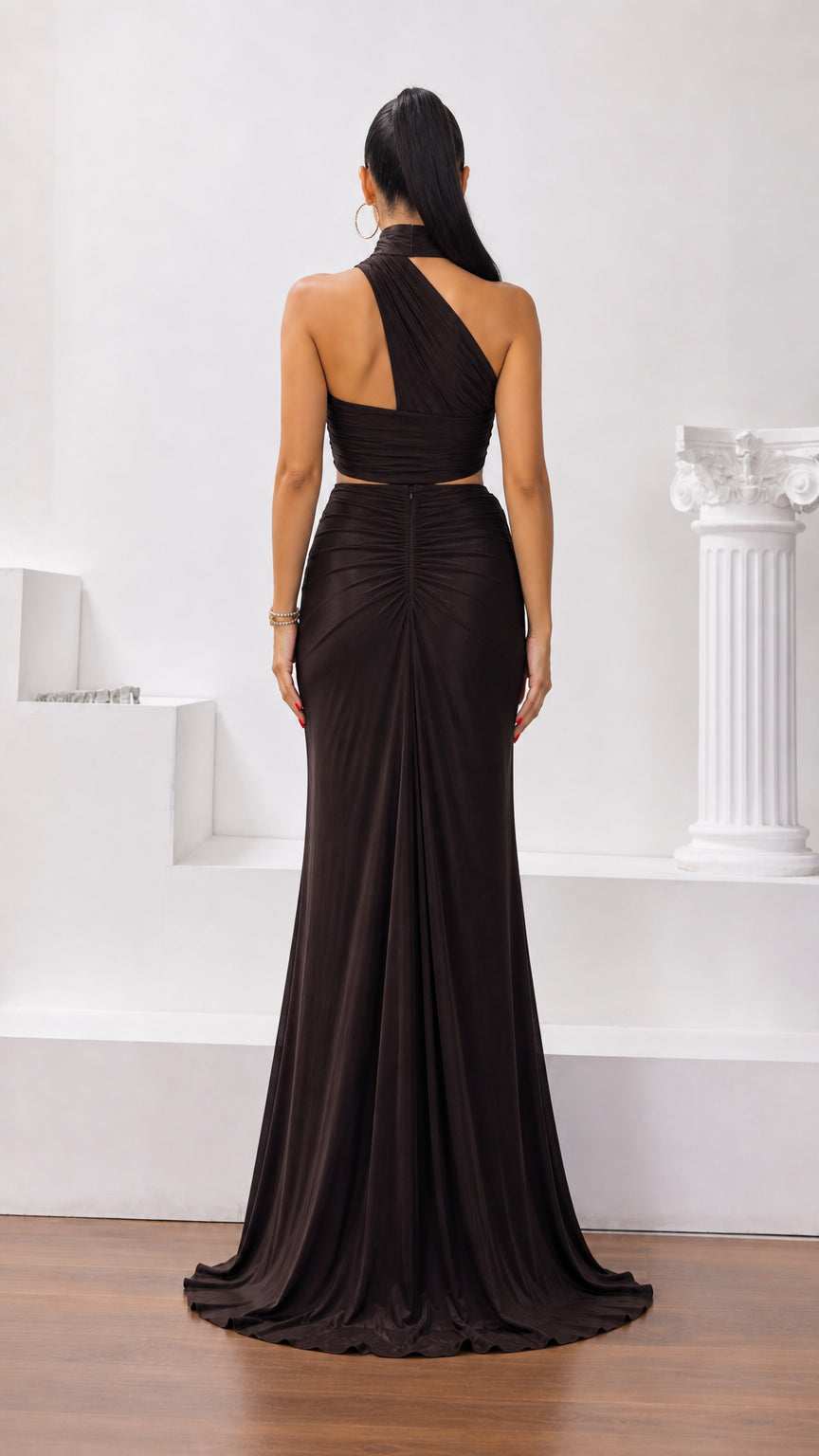 Back view of dark brown halter maxi gown showing asymmetrical back strap and flowing skirt
