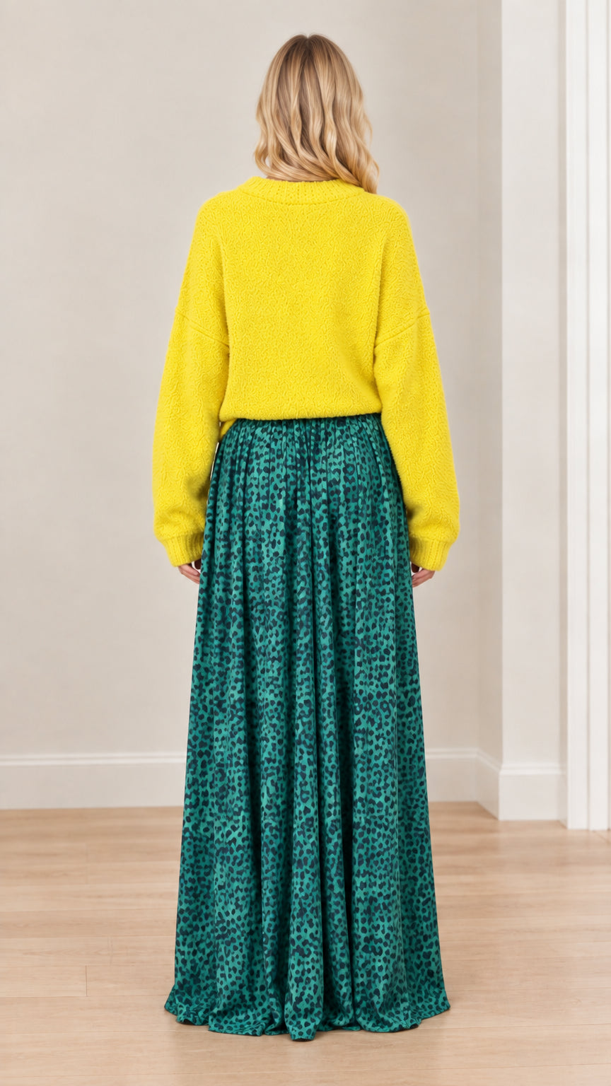 Back view of model in textured yellow knit sweater and flowing green leopard print trousers