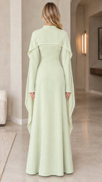 Back view of woman wearing sage green long-sleeve cape maxi dress