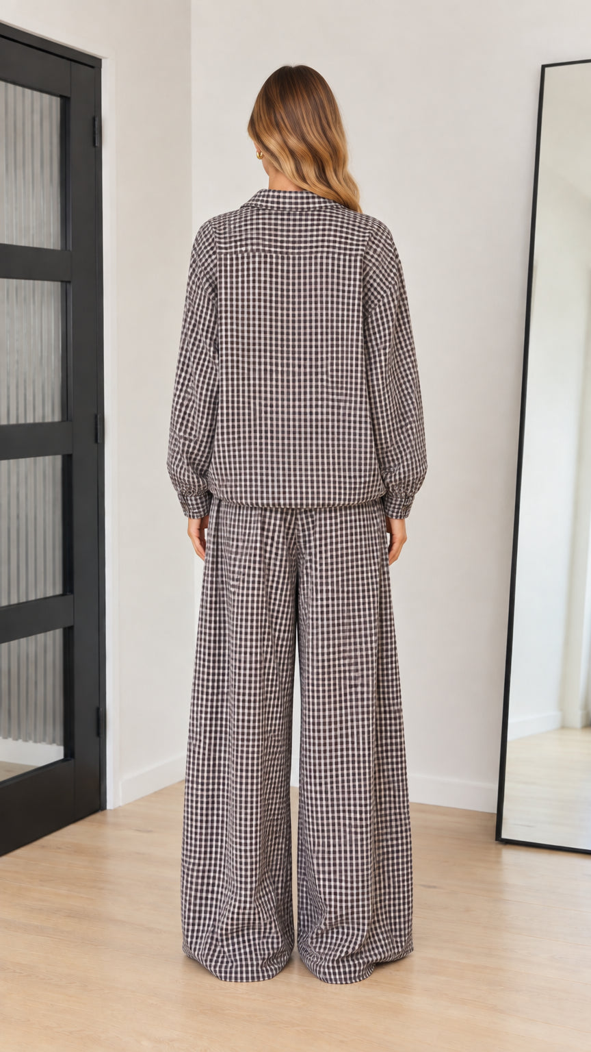 Back view of model showcasing brown gingham long-sleeve top and relaxed wide-leg trousers