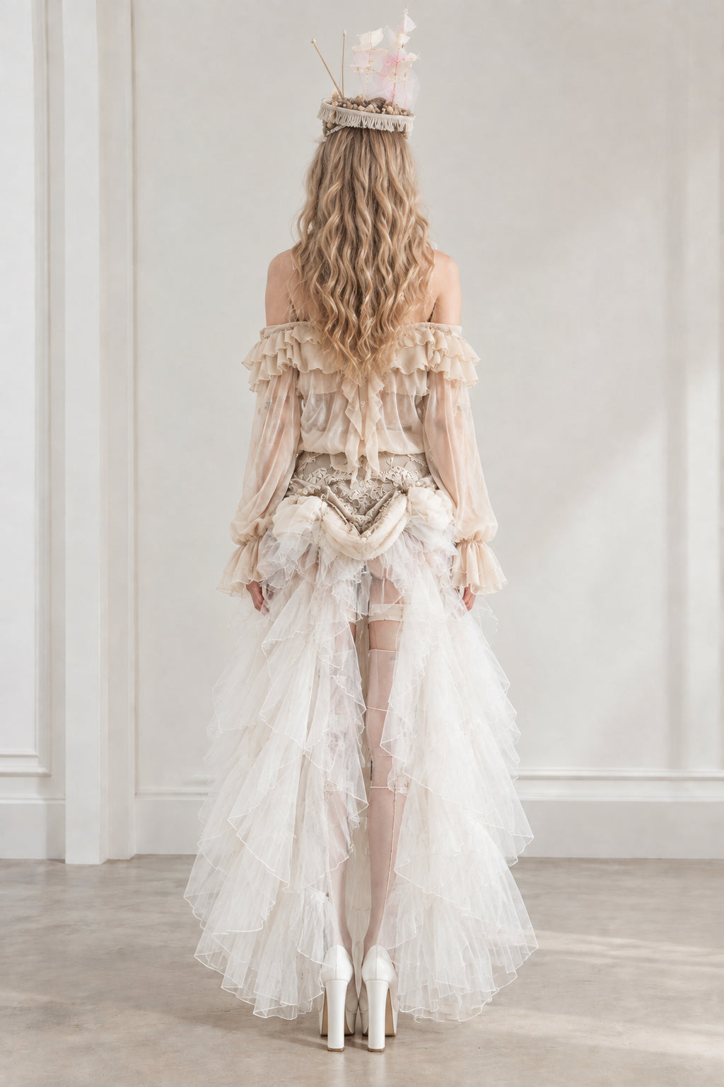 Back view of model showing flowing ivory high-low train and corset back