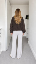 Back view of model wearing dark brown fleece jacket