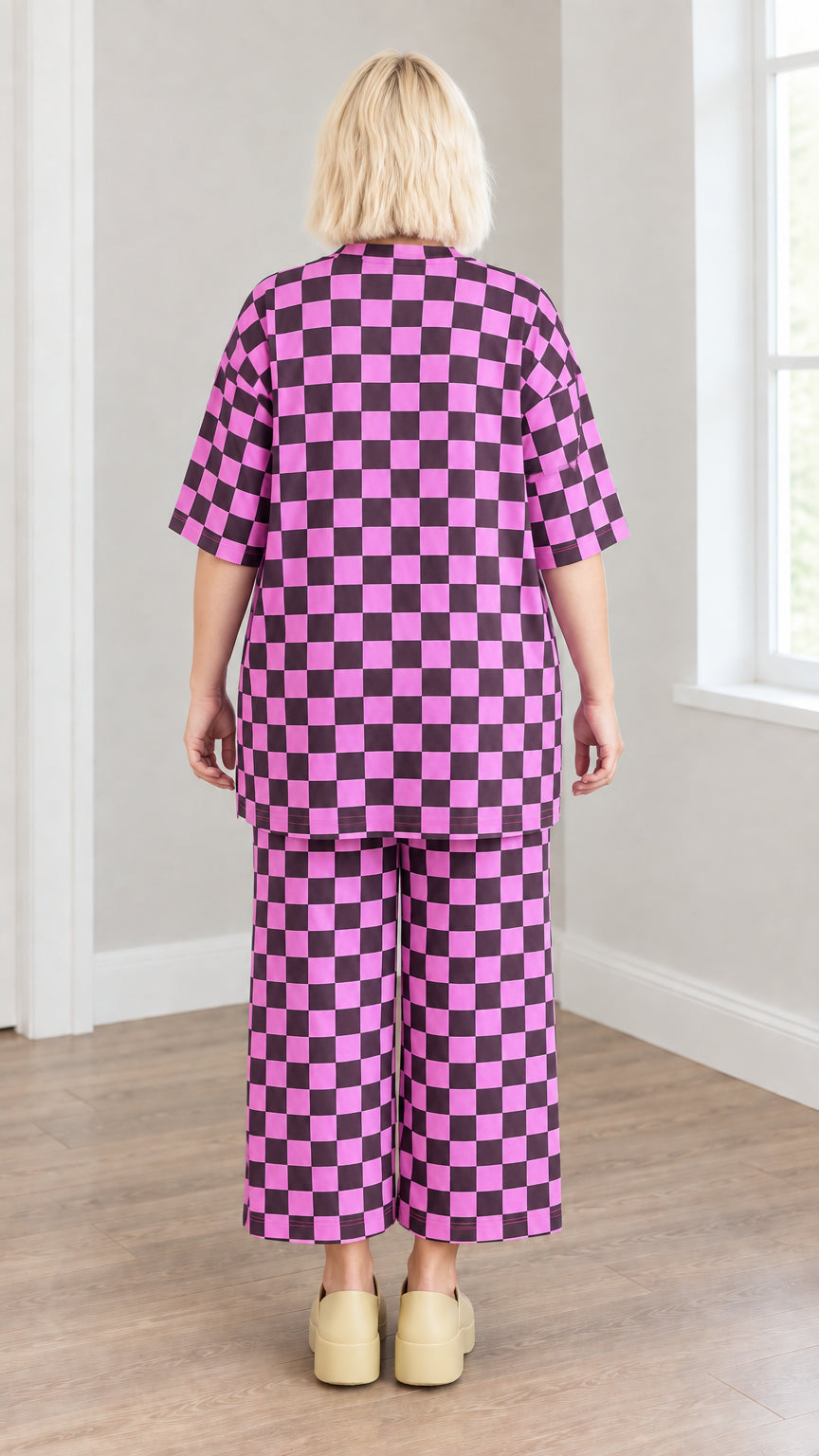 Back view of model in magenta and black checkered tunic top and cropped wide-leg pants