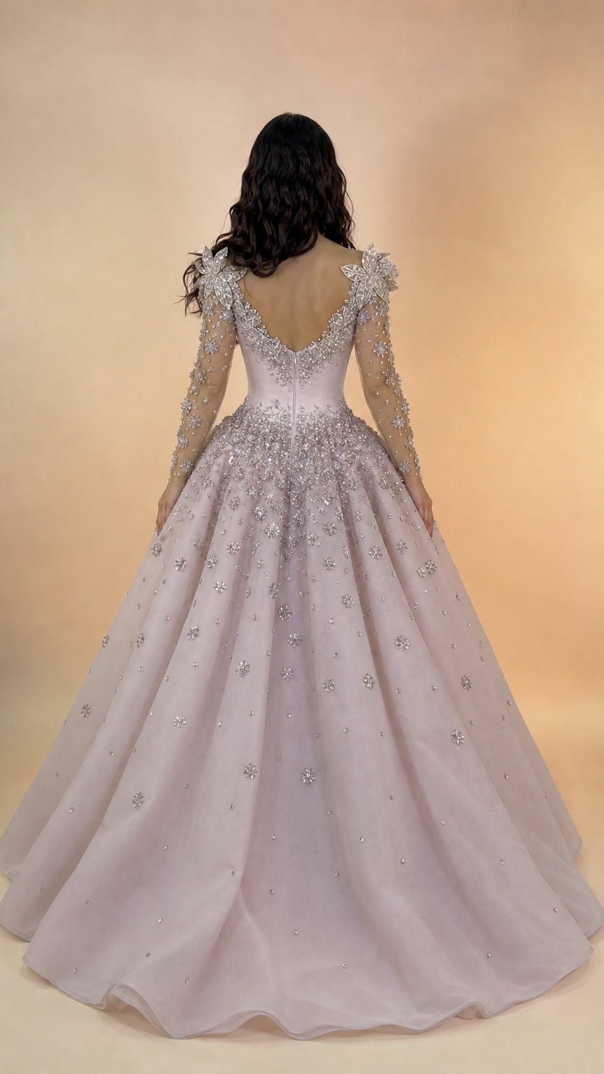 Back view of blush pink evening ball gown featuring low V-back and flowing train