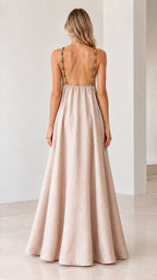 Back view of model showing open back and beaded straps on beige maxi dress