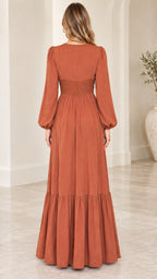 Back full-length view of woman wearing rust orange boho tiered maxi dress
