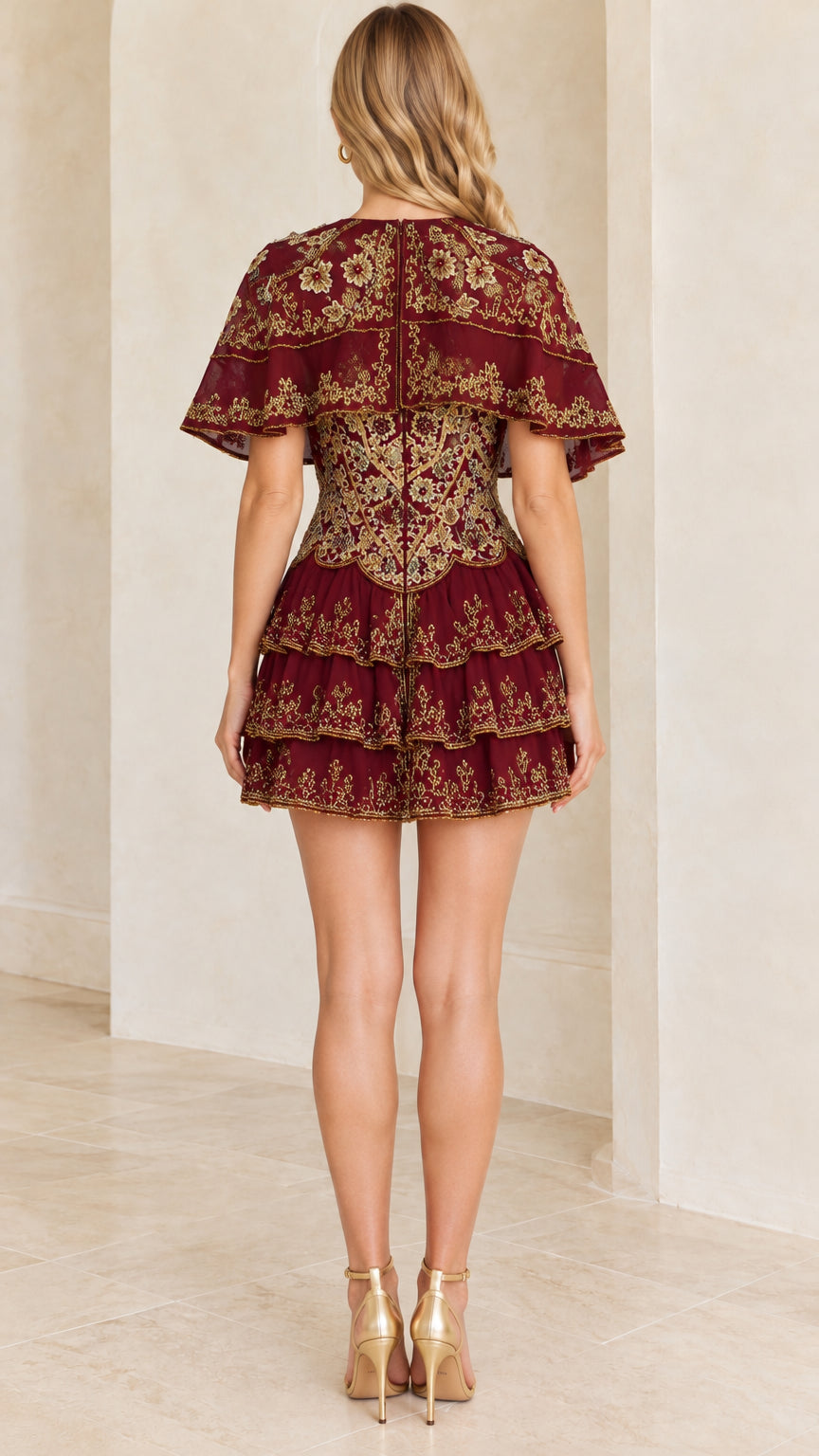 Rear view of woman showing back details of burgundy capelet mini dress
