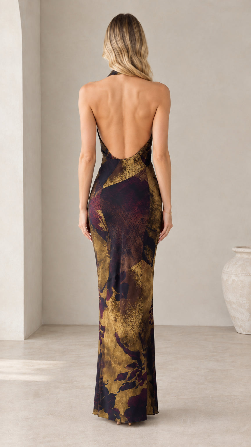 Back view highlighting the dramatic low open back of the halter maxi dress