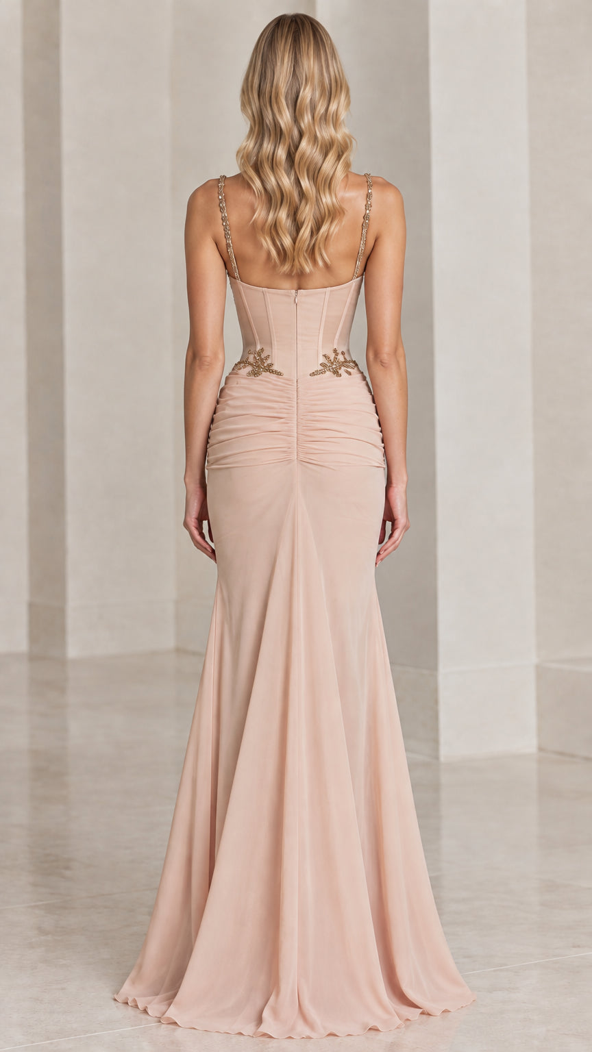 Rear view of blush mermaid gown highlighting fitted boned back and flowing skirt