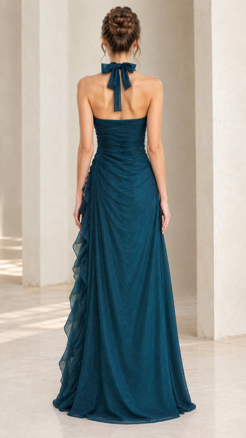 Back view of woman in teal blue evening gown displaying halter tie and open back