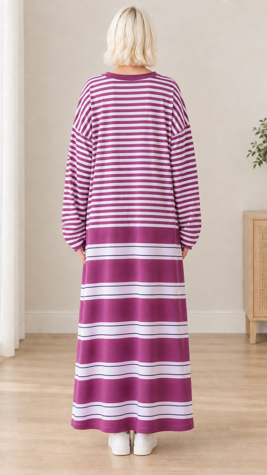 Back view of woman wearing purple striped long sleeve maxi dress