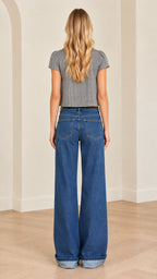 Back view of woman wearing gray fitted crop top paired with denim trousers