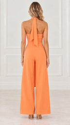 Model wearing orange halter neck two piece set showing tied back detail