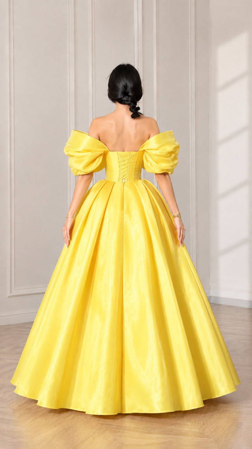 Back view of model showcasing the yellow gown with off-shoulder puff sleeves
