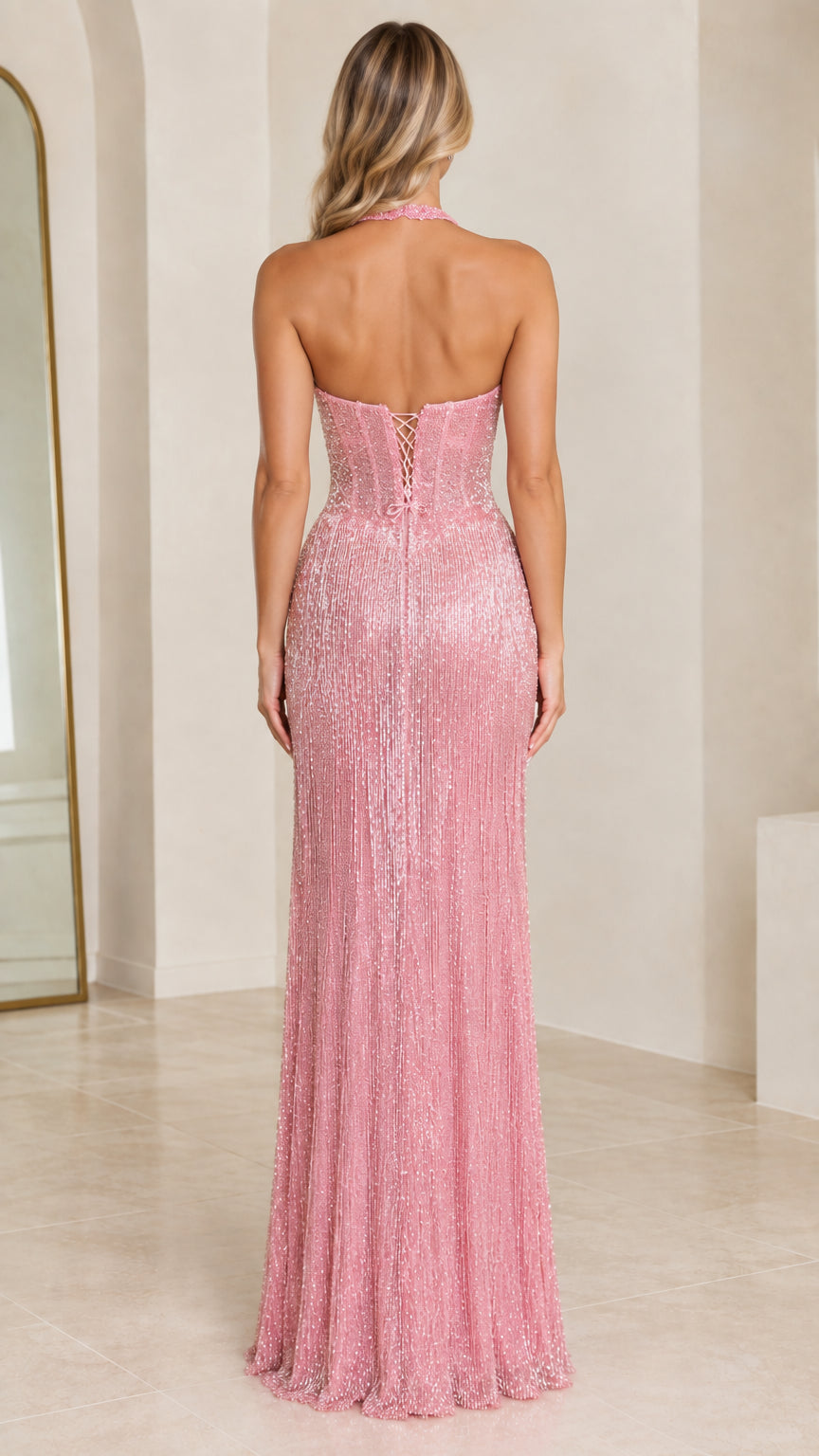 Back view of model showcasing pink lace-up halter corset back and floor-length skirt