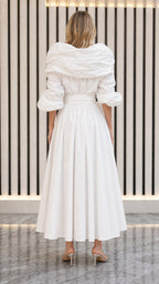 Back view of model in white pleated maxi dress showing collar structure