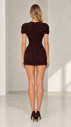 Back full-length view of brown high neck ruched mini dress showing zip closure