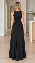 Back view of model wearing a floor-length black sleeveless maxi dress
