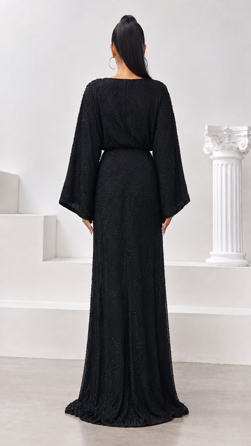 Back view of black beaded evening dress with fitted waist and flowing hem