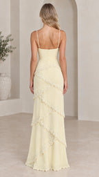 Back view of model in pale yellow sleeveless tiered ruffle maxi dress