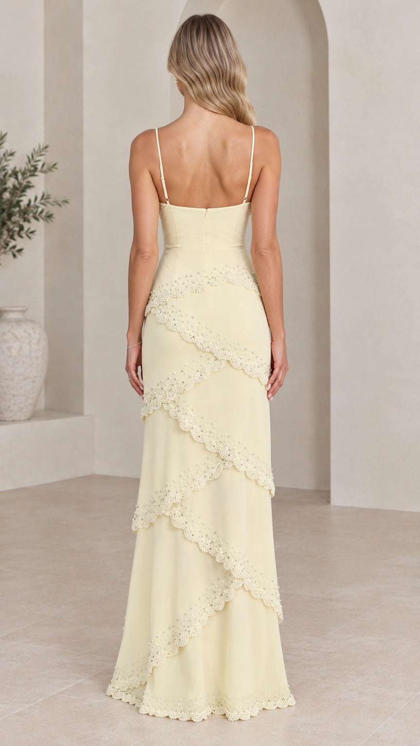 Back view of model in pale yellow sleeveless tiered ruffle maxi dress