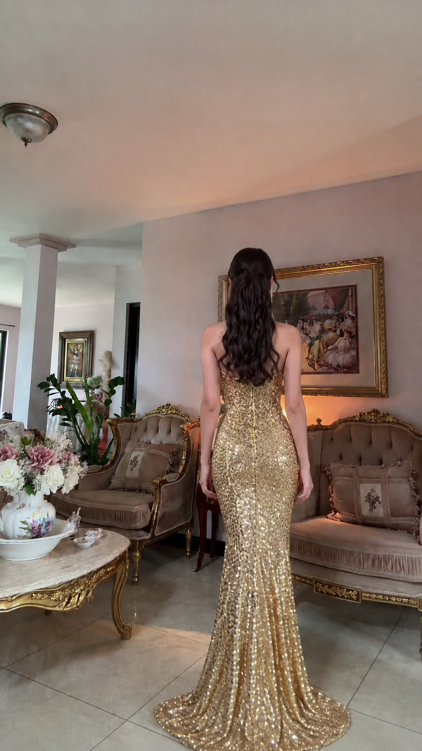 Back view of woman wearing gold sequin strapless evening gown with back zipper