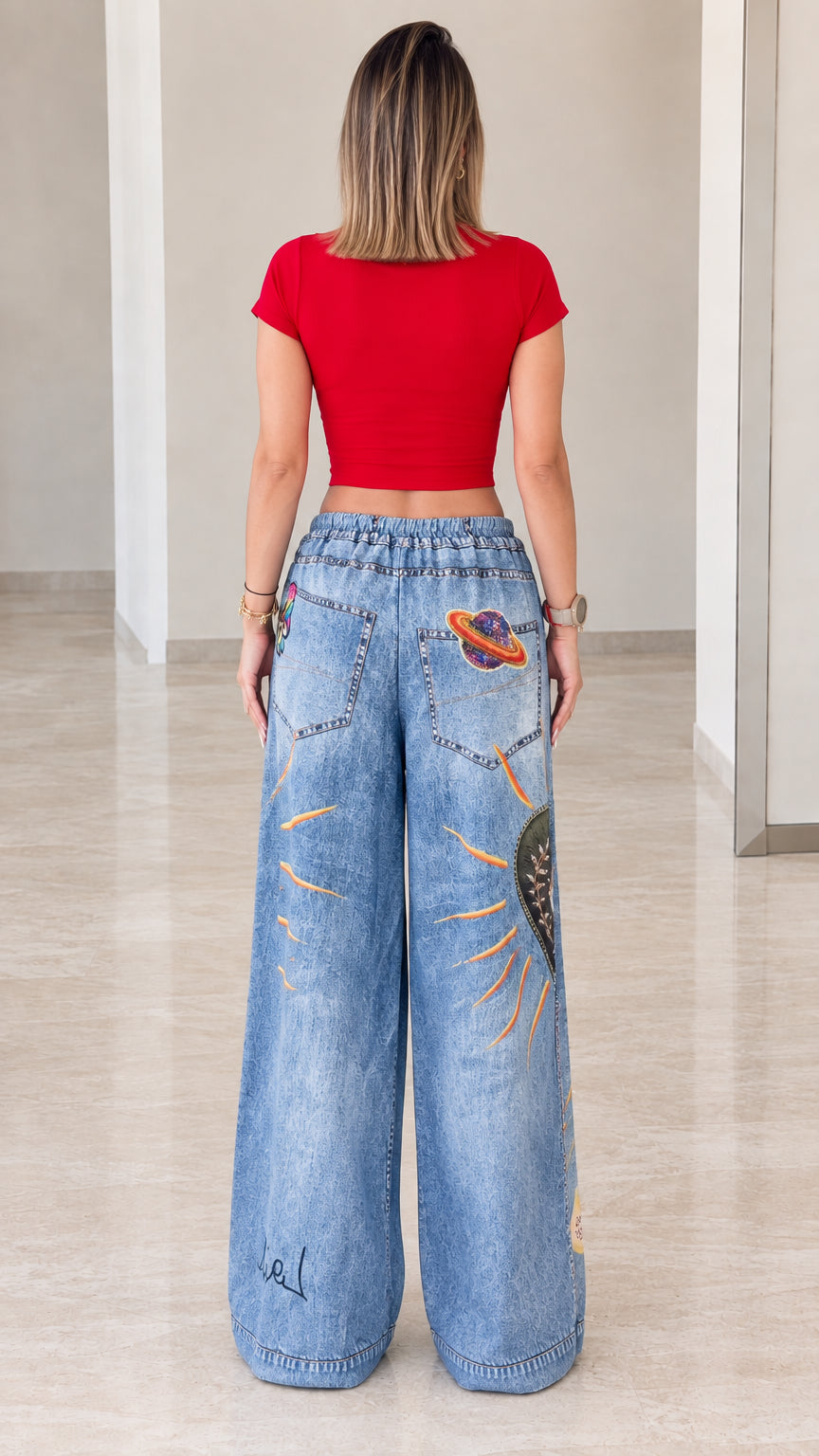 Back view of woman in red crop top and graphic printed wide-leg denim pants
