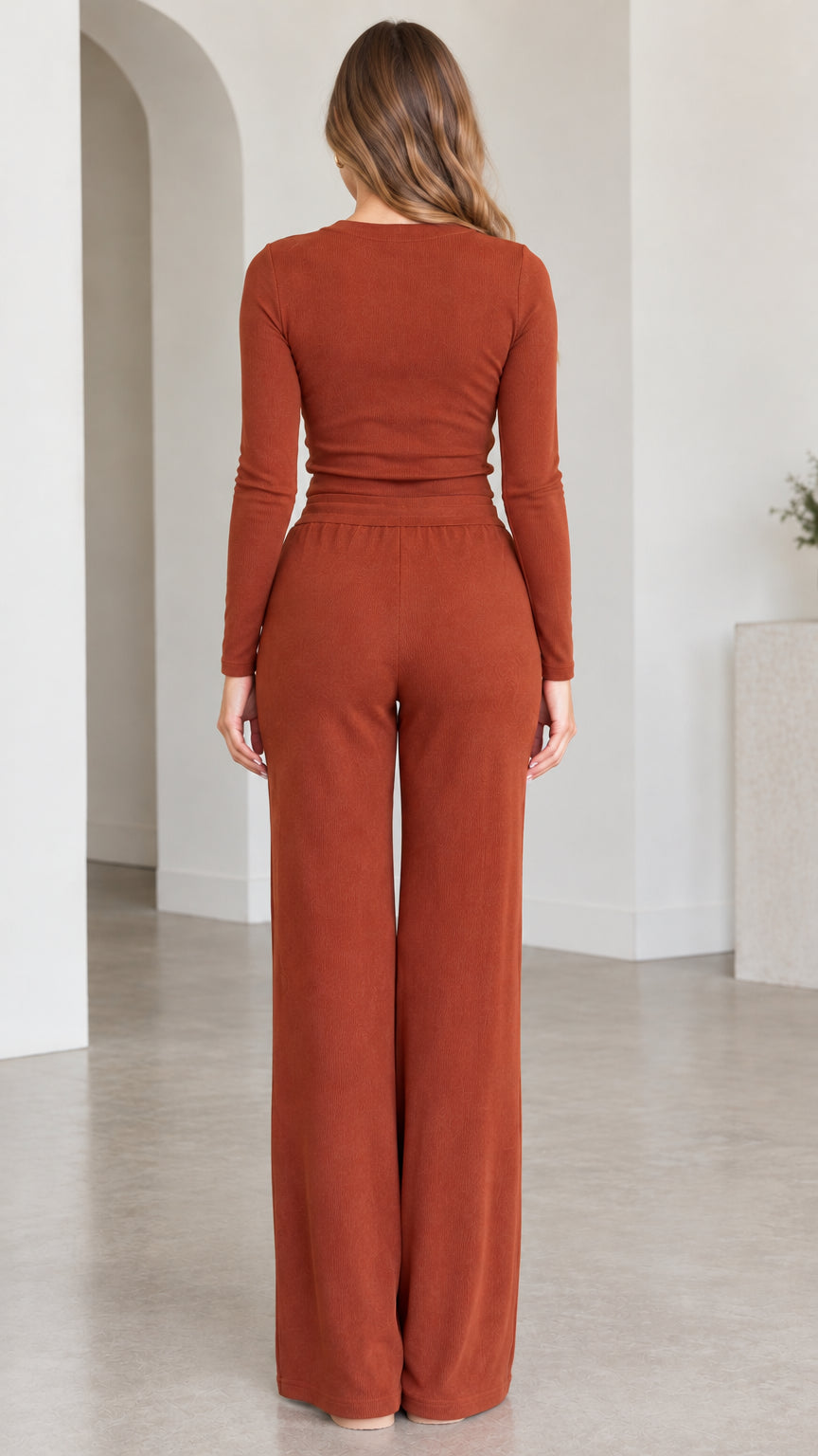 Rear back view of model wearing rust long sleeve top and wide leg lounge pants