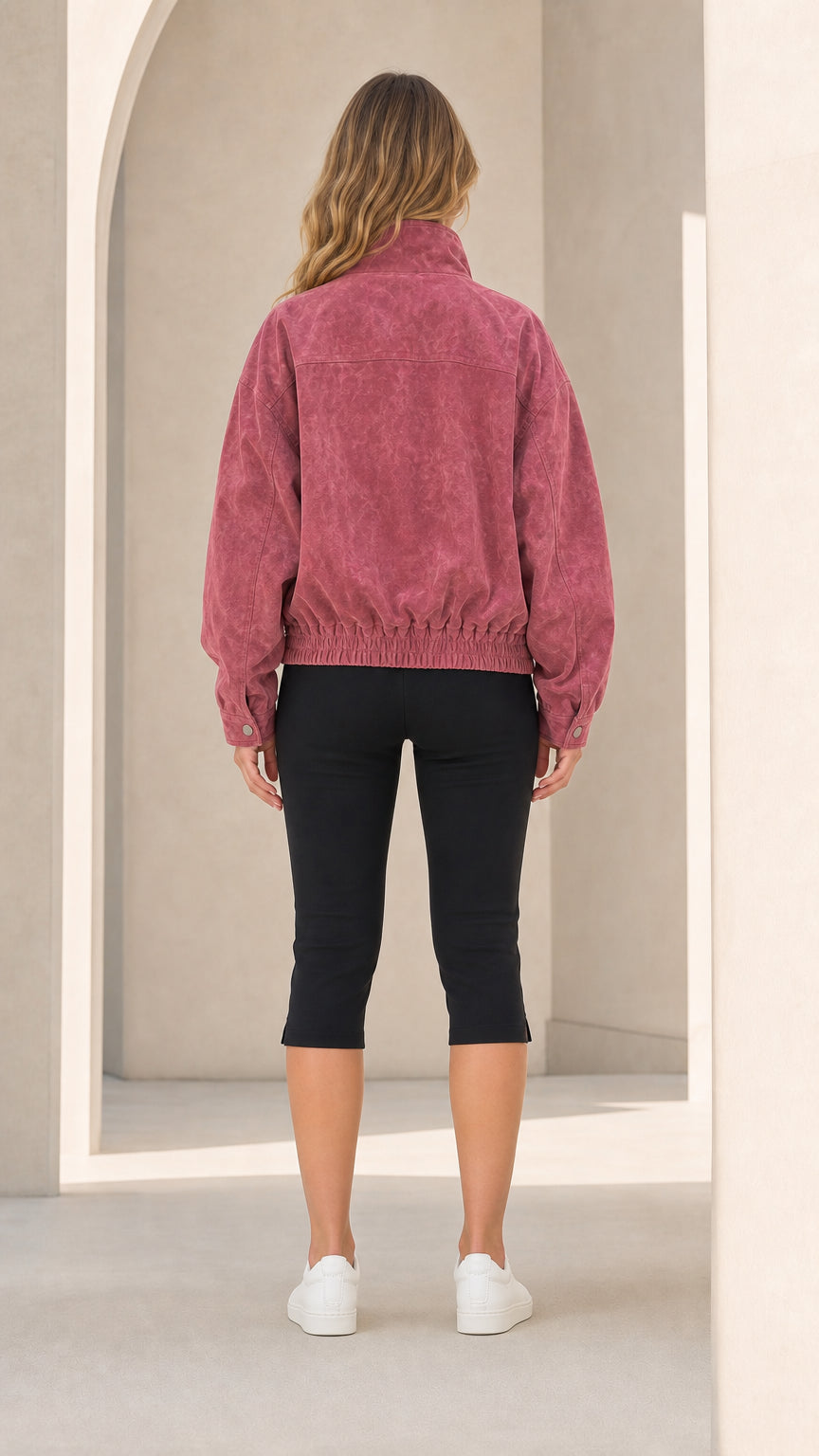Back view of woman wearing Dusty Rose zip-up bomber jacket showing elastic hemline