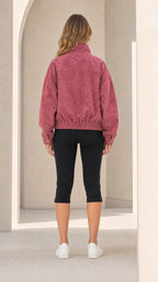 Back view of woman wearing Dusty Rose zip-up bomber jacket showing elastic hemline