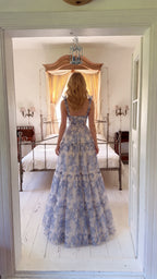 Back view of woman wearing blue floral corset maxi dress with lace-up back detail